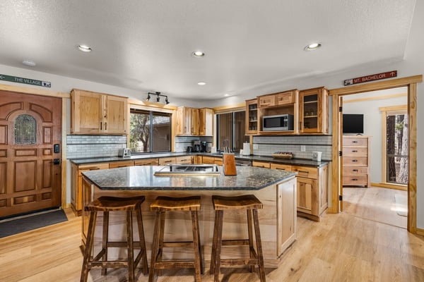 Cook your favorite meals in this spacious kitchen featuring granite countertops, rich wood cabinetry, and a large island perfect for gathering.