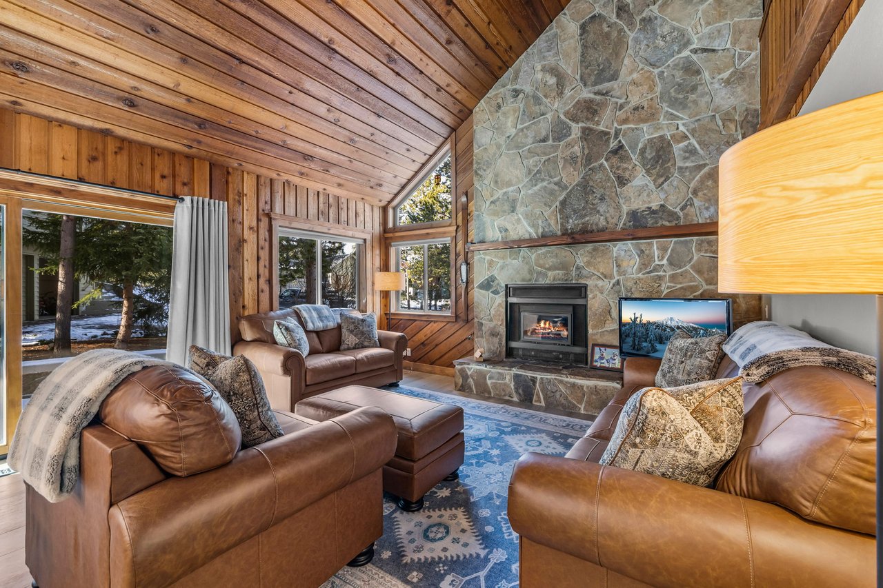 Sink into plush leather seating by your crackling stone fireplace, where warm wood surrounds you in mountain comfort.