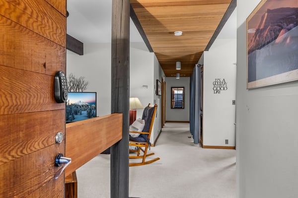 Step into your modern mountain retreat where exposed wooden beams meet contemporary comfort, complete with entertainment and cozy seating.