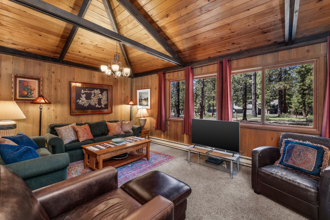 Your cozy retreat awaits with vaulted wood ceilings, plush seating, and serene forest views—curl up here after a day of adventure and feel truly at home.