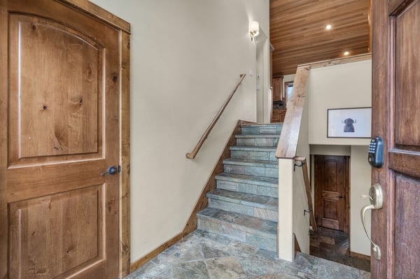 Rich wood details and stone stairs create a warm, mountain lodge atmosphere as you move between levels of your retreat.