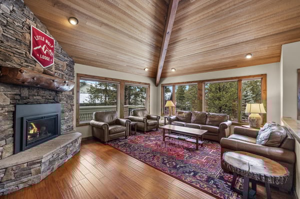 Gather around the crackling fireplace in your spacious living room, where leather seating and mountain lodge charm create the perfect retreat.