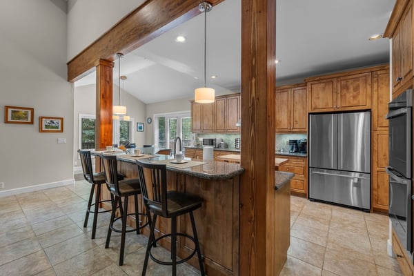 Step into an open-concept kitchen and dining area crafted with rich wood tones and modern appliances. You'll love the spacious island—perfect for morning coffee or gathering with friends.
