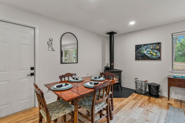 Gather around a warm dining table with a cozy wood-burning fireplace setting the scene for memorable meals together.