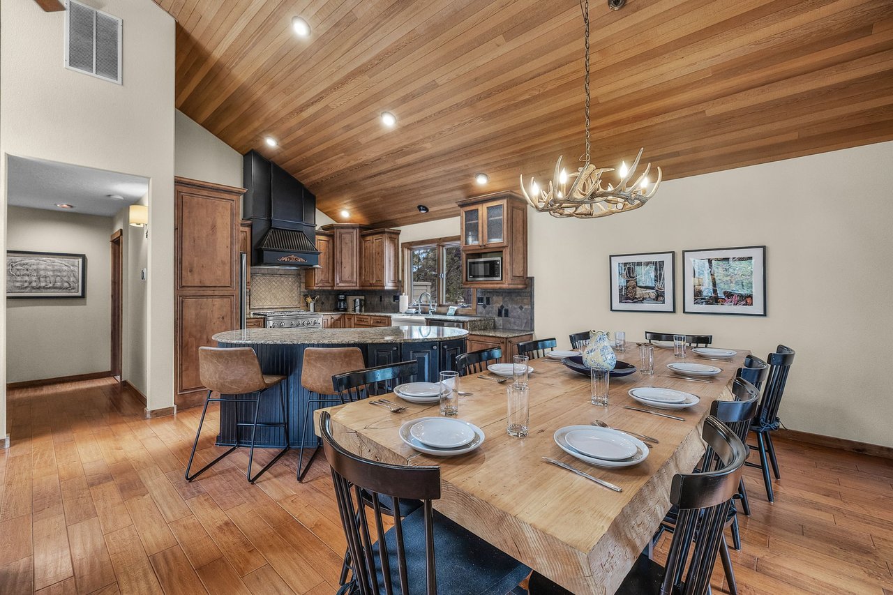 Gather around the stunning live-edge dining table where your group can savor meals beneath soaring wood ceilings and rustic antler chandelier.