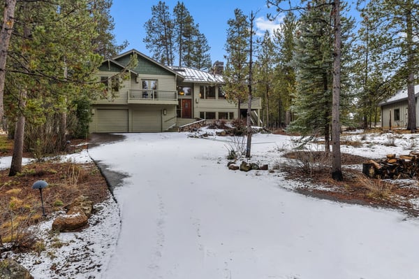 Mountain retreat nestled among towering pines with snow-dusted grounds and peaceful forest surroundings.